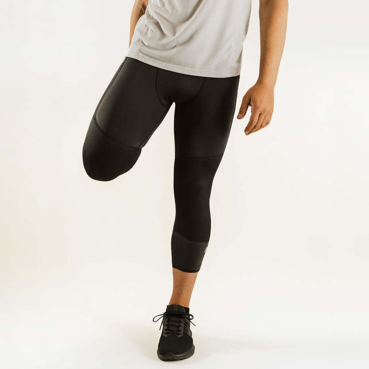 Black 7/8 thermal base layer leggings with knee support, worn with sneakers