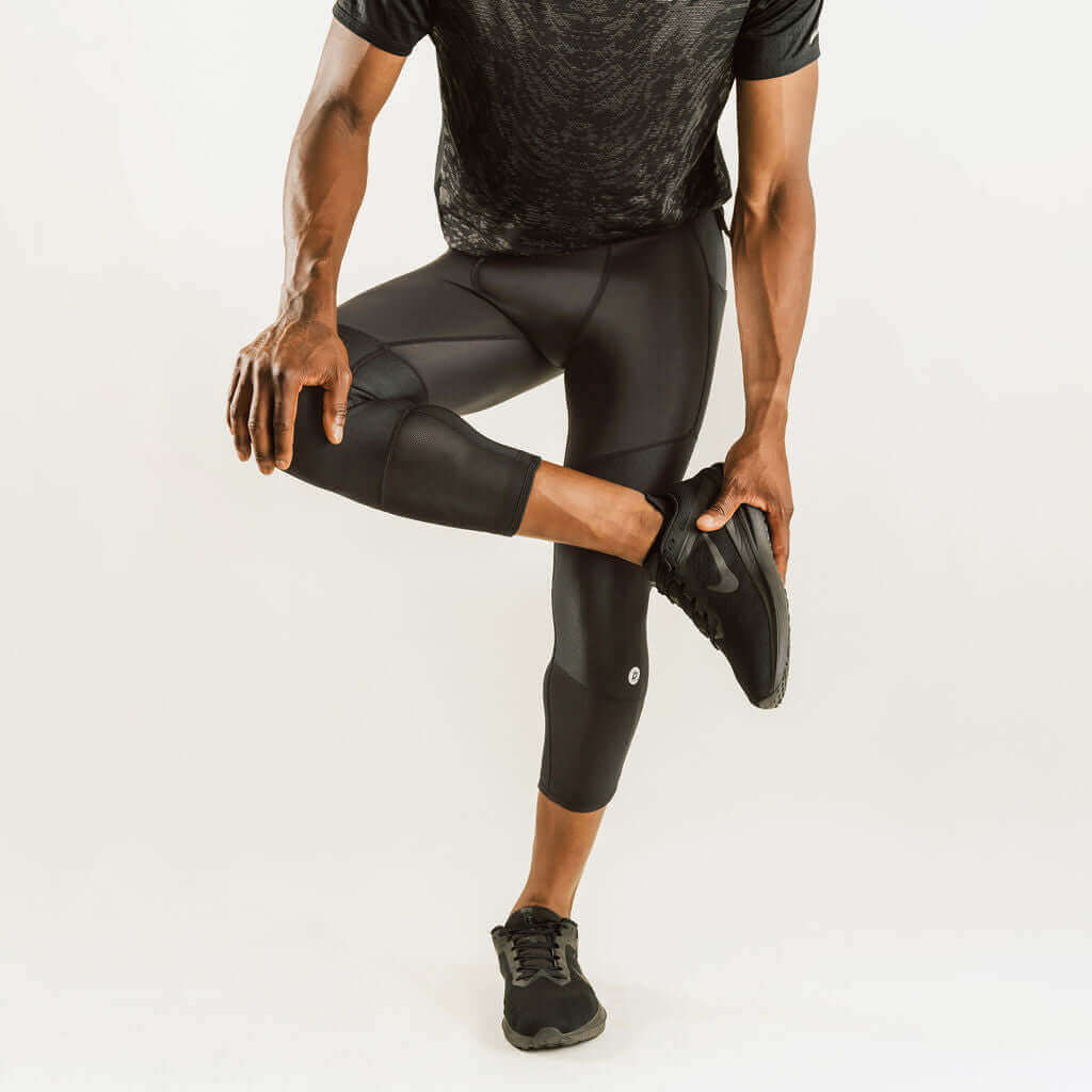 Men's knee support compression pants, 7/8 length, black, side view with knee reinforcement