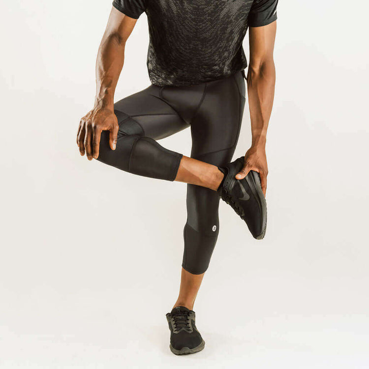 Men's knee support compression pants, 7/8 length, black, side view with knee reinforcement