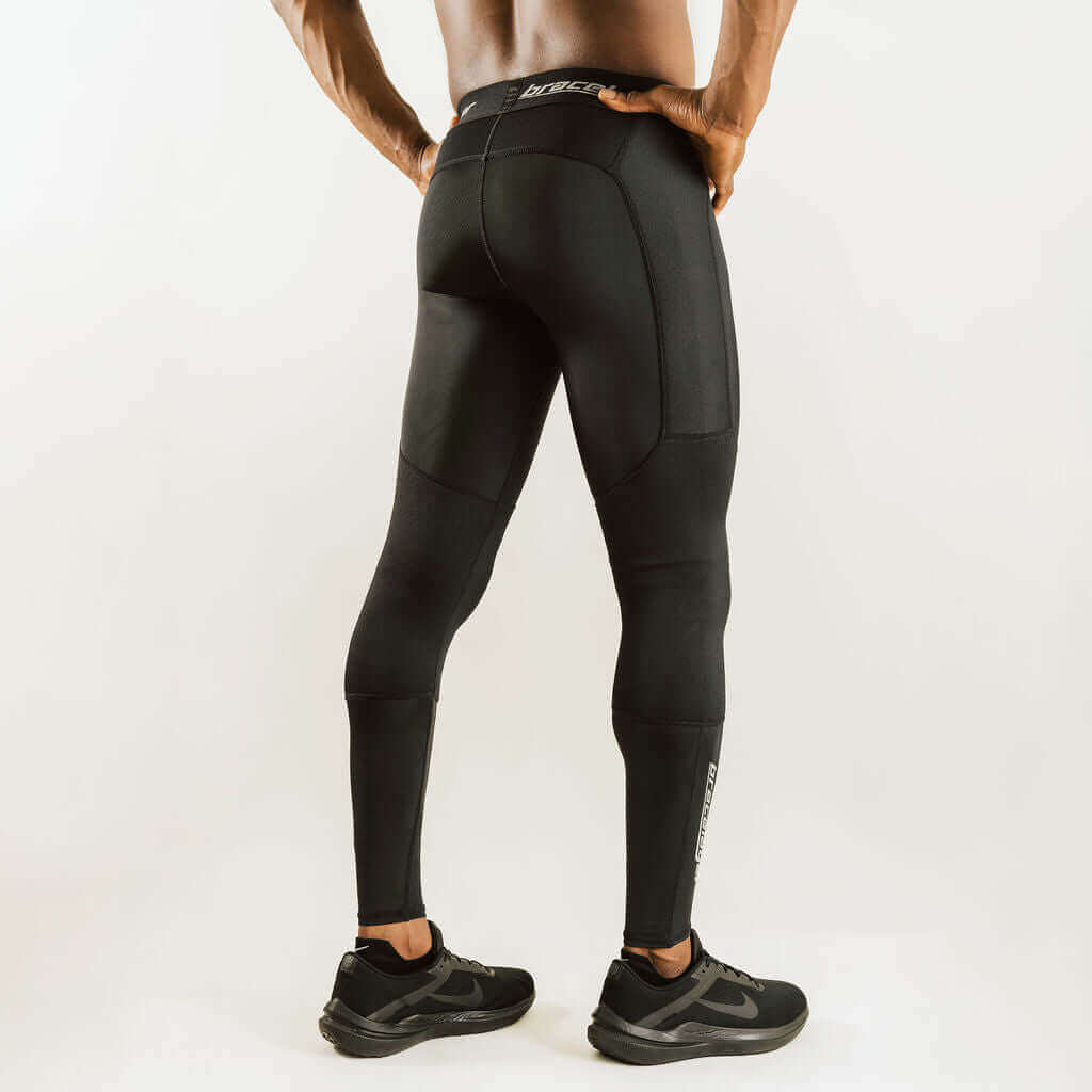 Black knee support compression pants, side view with knee paneling and ankle cuffs.