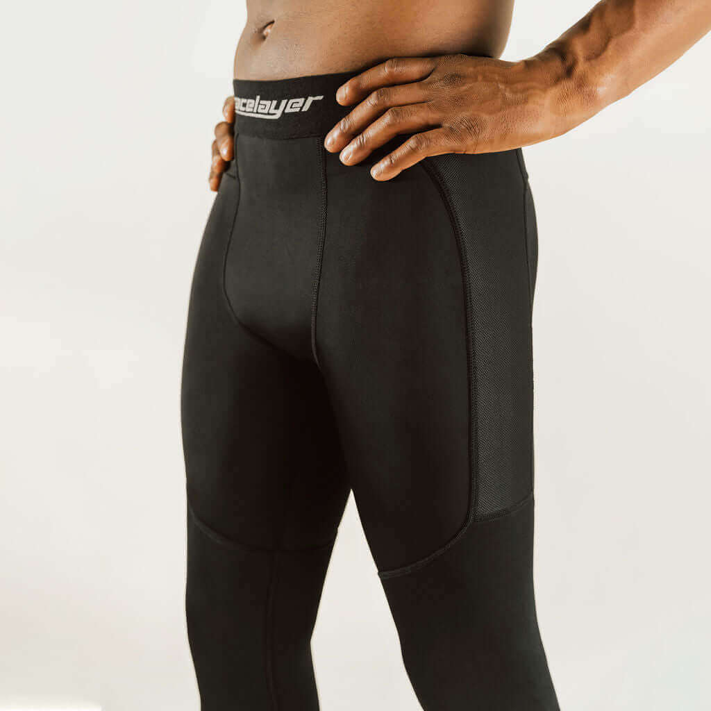Black compression pants with front seams and knee paneling; logo waistband.