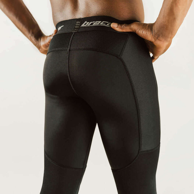 Black knee support compression pants with contoured seams and knee pad panels.