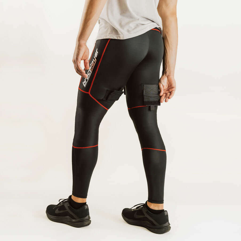 Black hockey compression pants with red piping and knee support pads, side view