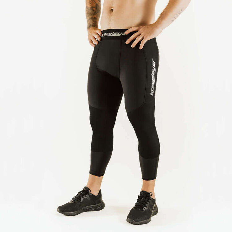 Black thermal base layer leggings with knee support, front view with thigh logo