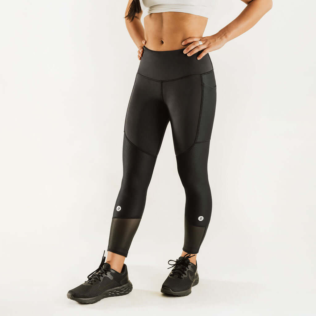 Black 7/8 compression support pants with two knee logo patches on front