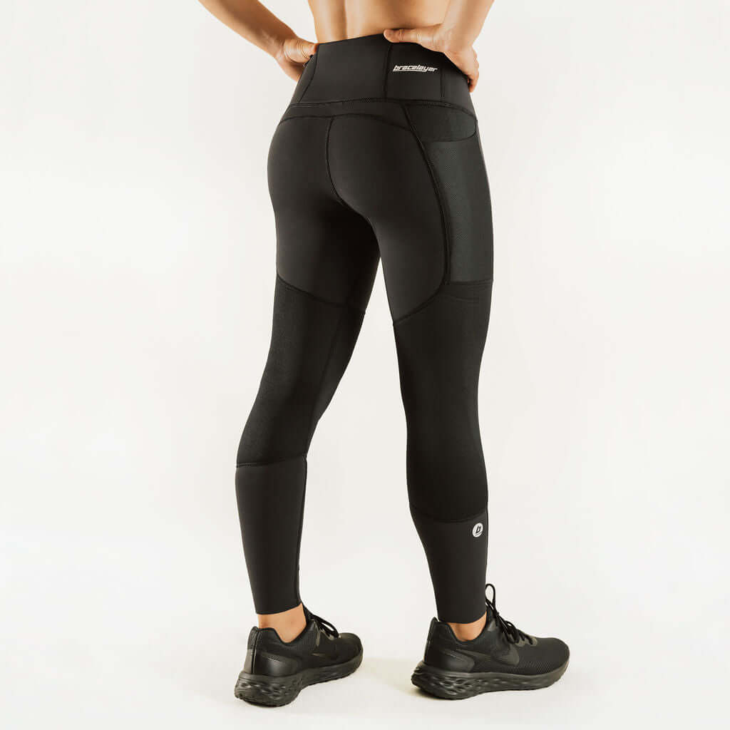Black compression leggings with wide waistband and sculpted knee support panels.