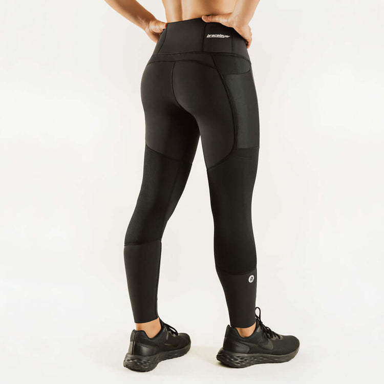 Black compression leggings with wide waistband and sculpted knee support panels.