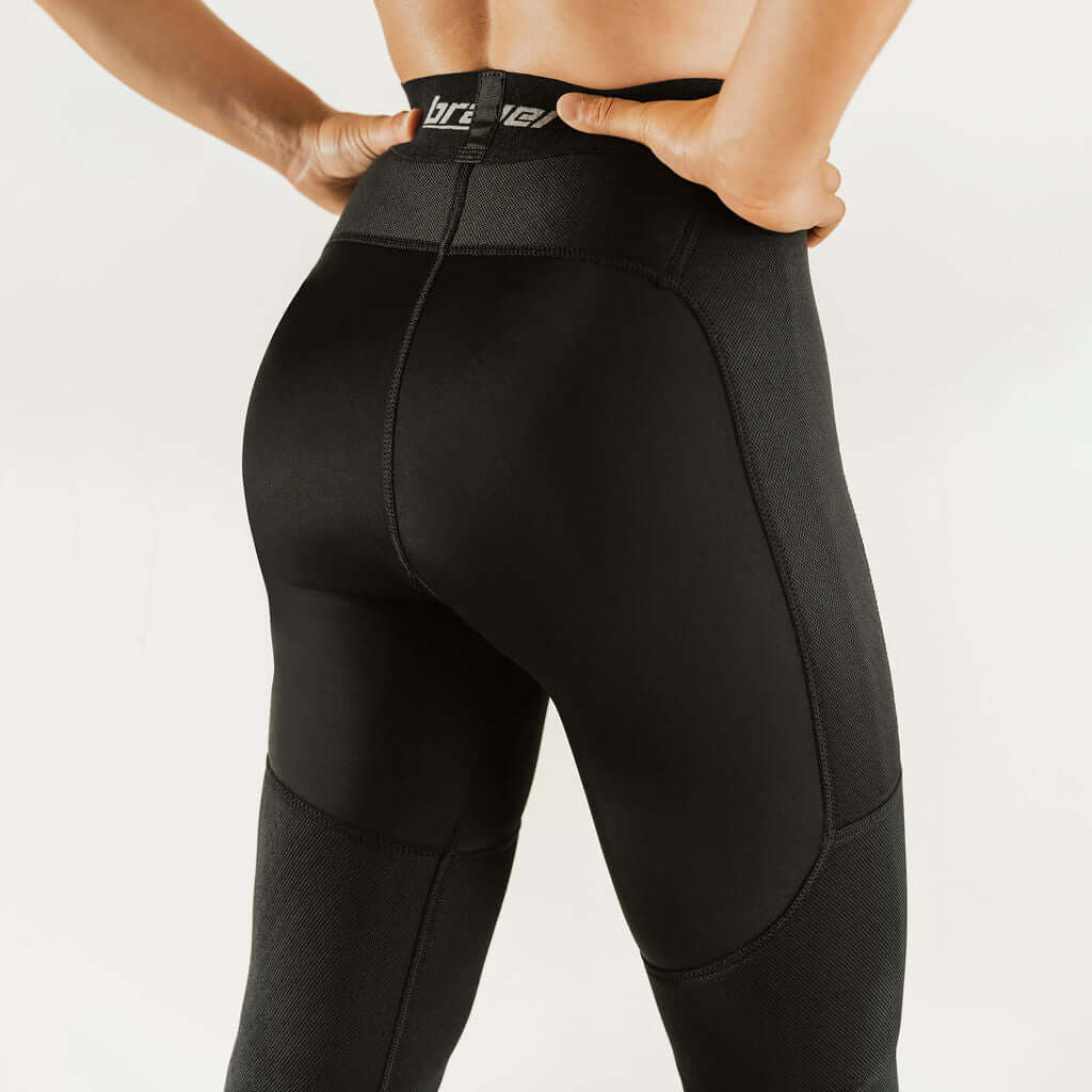 Black knee support compression pants with curved panel seams and waistband logo.