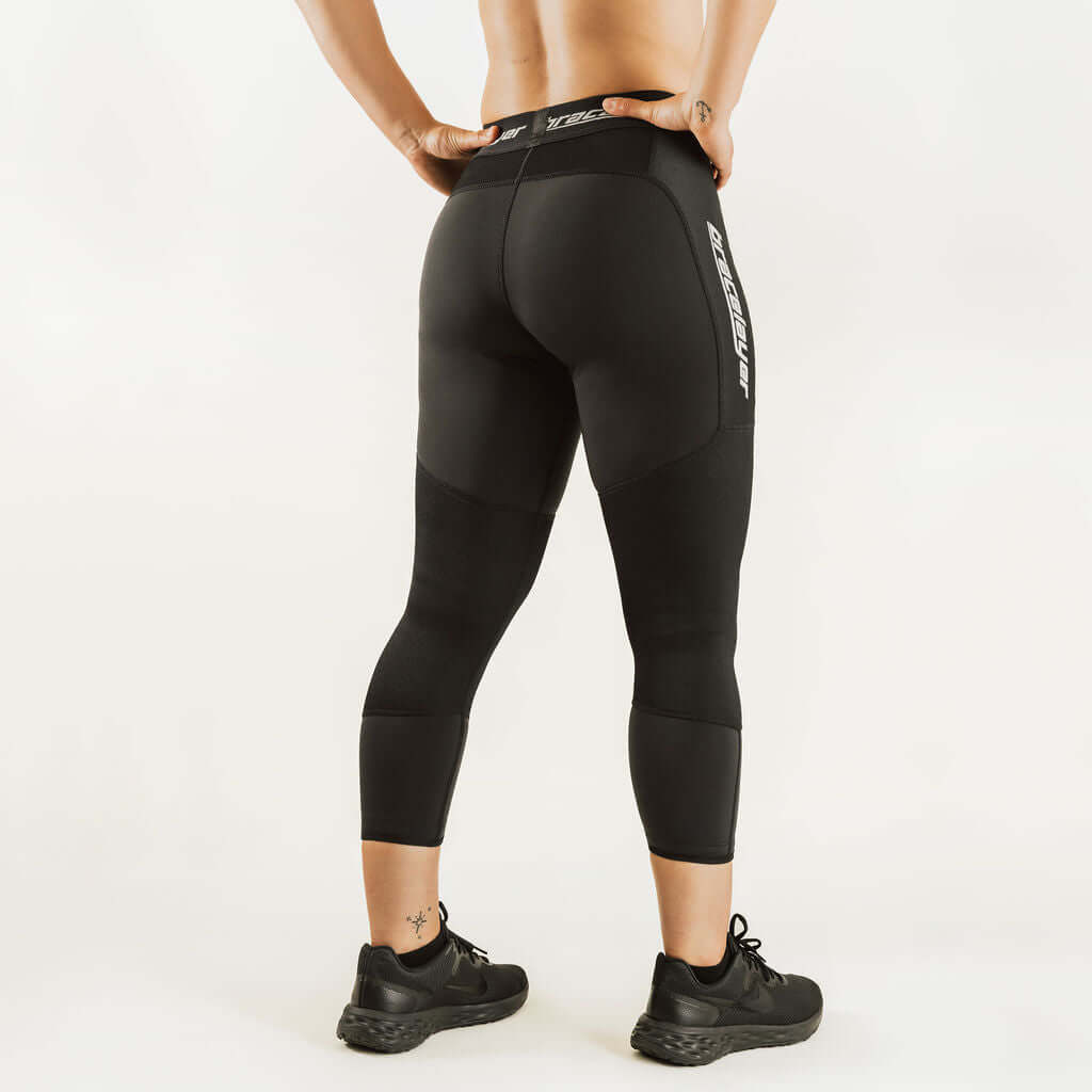 Black 7/8 thermal leggings with rear panel seams and logo print, women's base layer