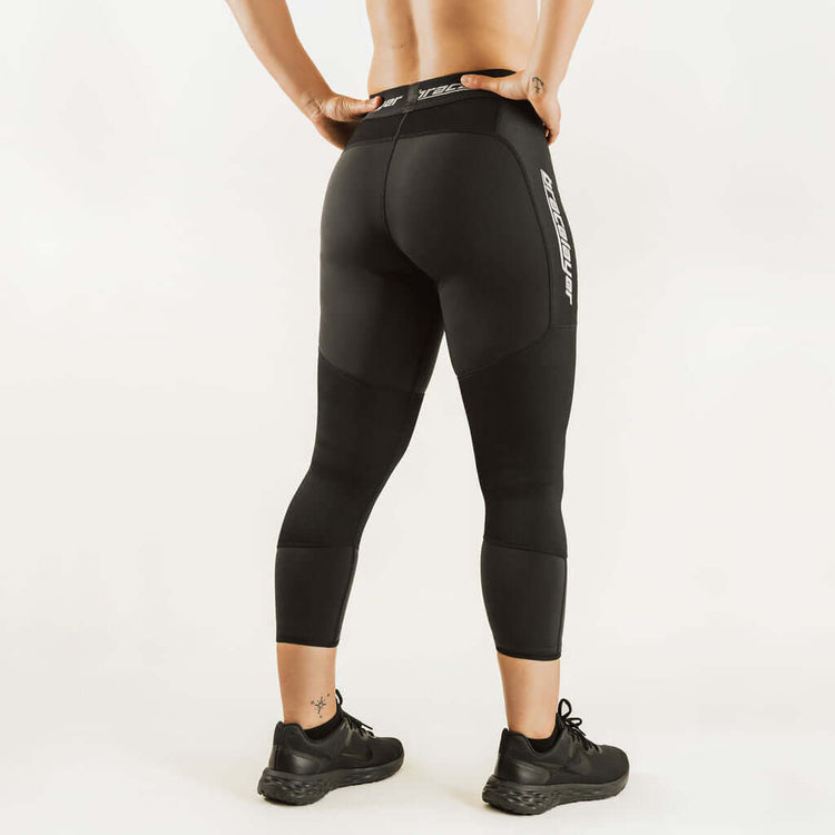 Black 7/8 thermal leggings with rear panel seams and logo print, women's base layer
